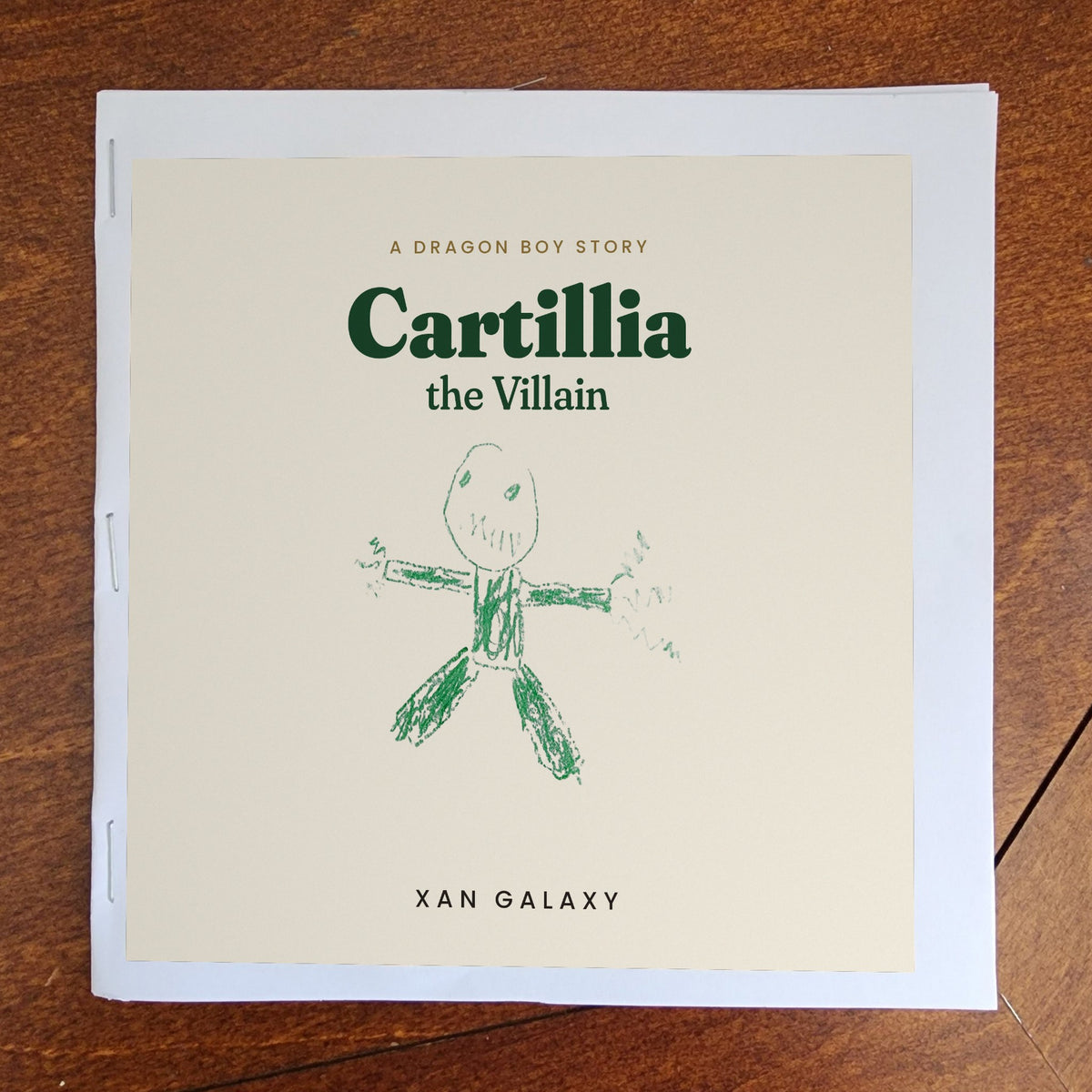 Sample home print PDF booklet as it comes off a home printer: the cover printed with a white paper border, folded and stapled along the spine