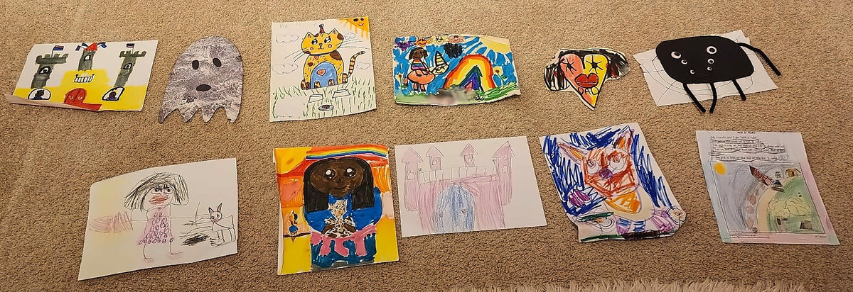 A child's drawings and crafts laid out on the floor